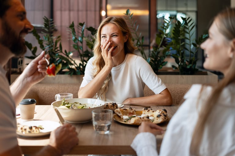 Three friends enjoying a delightful meal at a restaurant, sharing laughter and stories